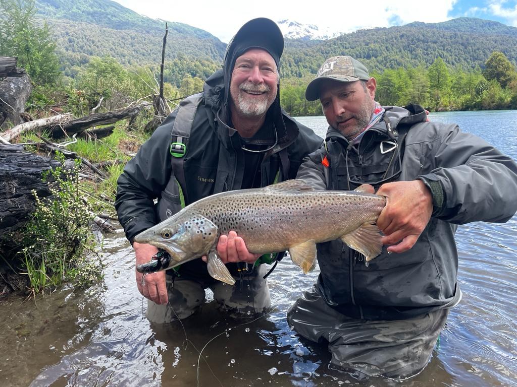 José Marti and a guest with a brown trout on a lake near Coyhaique, Patagonia